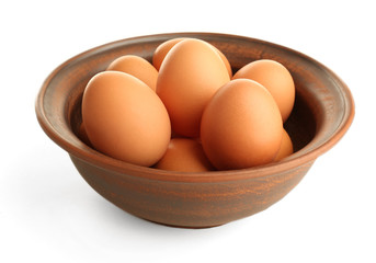 Eggs in clay bowl isolated on white