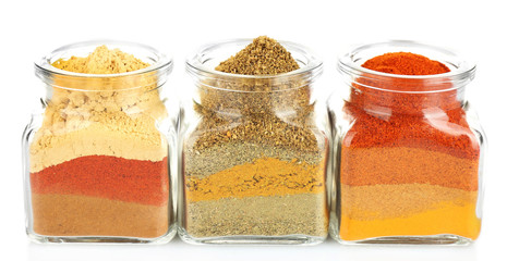 Different kinds of spices in glass bottles isolated on white