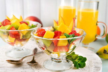 Fruit salad with mint and orange juice in glassware