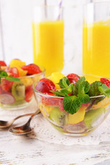 Fruit salad with mint and orange juice in glassware