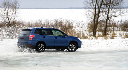 Powerful offroader car sliding by lake ice
