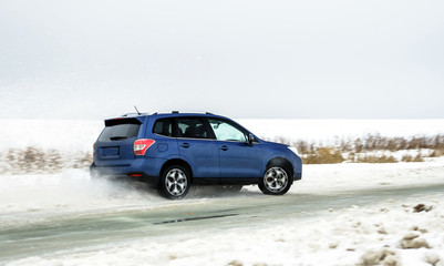 Obraz na płótnie Canvas Powerful offroader car sliding by lake ice