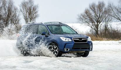 Powerful offroader car sliding by lake ice