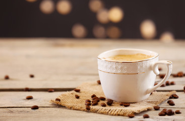 Cup of coffee on table on brown background