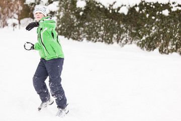 Fototapeta na wymiar Young boy enjoying a winter snowball fight