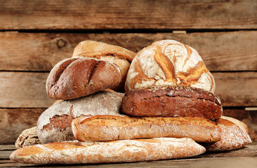 Different fresh bread on old wooden table