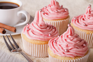 Cupcakes with pink cream and coffee close-up, horizontal