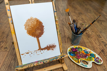easel with tree drawing with paint for art school