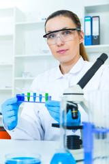 Woman working with a microscope in a lab, 