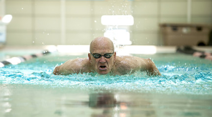 senior man swimming competitively