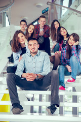 Happy teen girls and boys on the stairs school or college. Selec