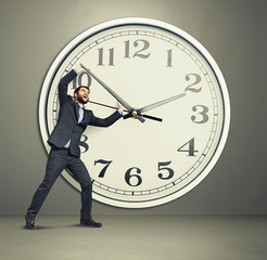 businessman picks up the clock