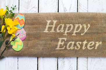 Colorful easter eggs on linen cloth with Happy Easter text - obrazy, fototapety, plakaty