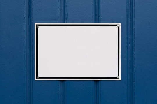 Ein leeres weisses Schild auf blauen Brettern