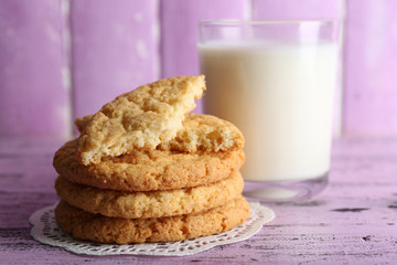 Fototapeta na wymiar Tasty cookies and glass of milk on color wooden background