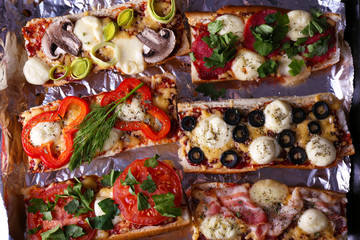 Different sandwiches with vegetables and cheese on pan close up