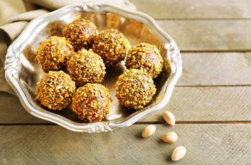 Tasty homemade pistachio candies on wooden table