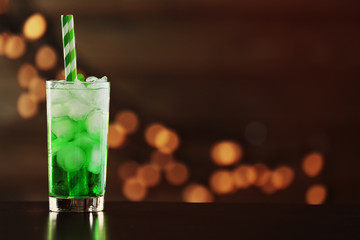 Green cocktail on table on brown background