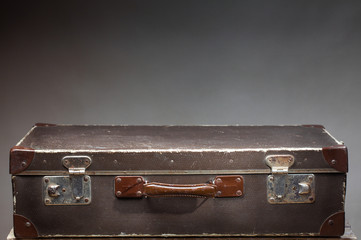 Old vintage suitcase on wooden table