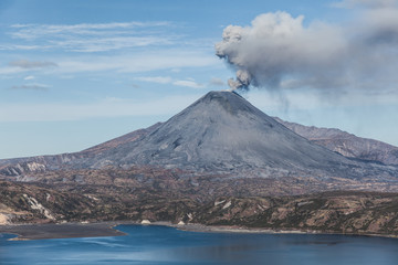 Volcanic eruption. Smoke over lake.