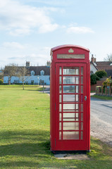 Fototapeta na wymiar British Telecom red telephone box in a Suffolk Village, UK