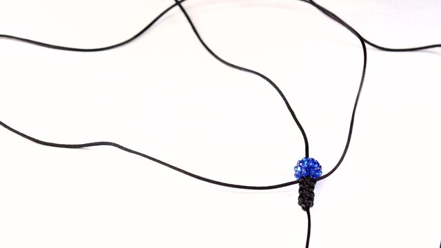 Woman makes popular bracelet shamballa on a white background