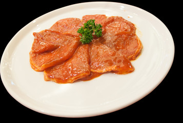 slided pork mixed with sauce on white dish