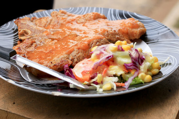 Steaks, pork, french fries with salad.