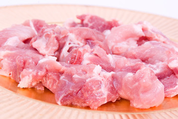 Peaces of fresh uncooked pork on a golden plate