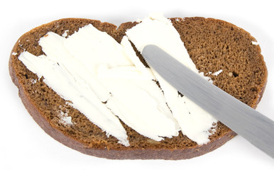 A peace of bread, knife and butter isolated on white background