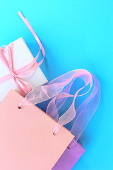 Colorful shopping bags and gift box on light blue background