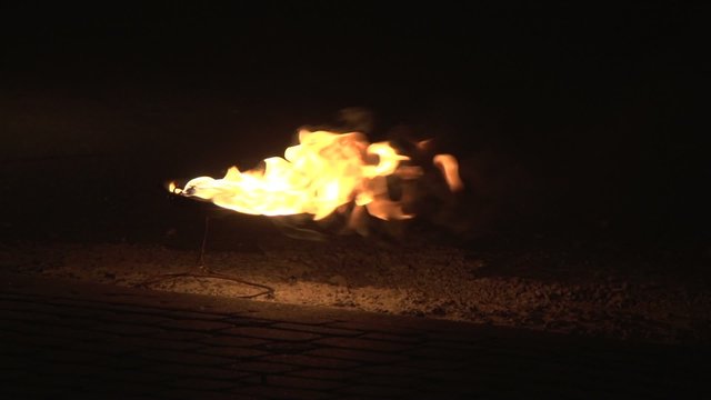Fire burning in a bowl on the street at night