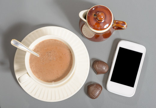 cup of hot chocolate with a phone
