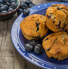 Homemade muffins with blueberries on a wooden background