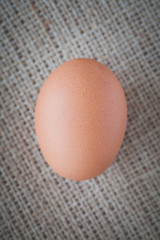 Healthy food brown chicken egg on brown fabric background