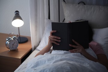 Junge Frau im Bett am lesen
