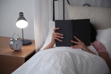 Junge Frau im Bett am lesen
