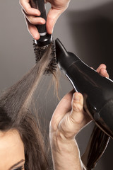 Naklejka premium hairdresser doing his client hair with a hair drier and comb