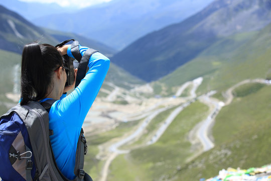 woman photographer taking photo at plateau mountain peak in tibe