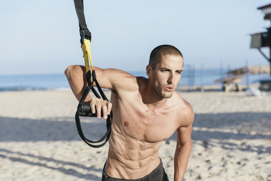 Young man athlete doing cross training workout at the beach