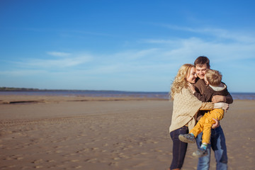 A young family kissing and embracing at the beach