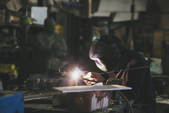 Man with mask welding in a workshop