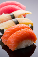 Sushi nigiri set on a stone plate over black background