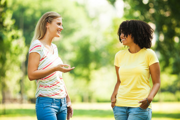 Two young women talking in park