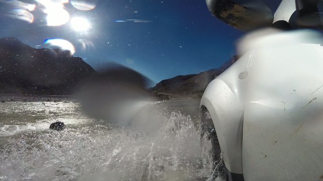 4wd car wades a river in Atlas Mountain, Morocco