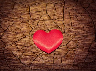 Red heart on a cracked wood grain background