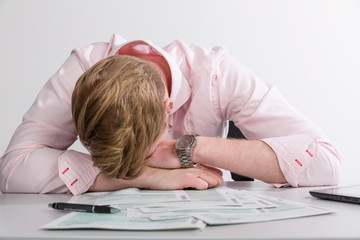 Junger Mann verzweifelt am Schreibtisch