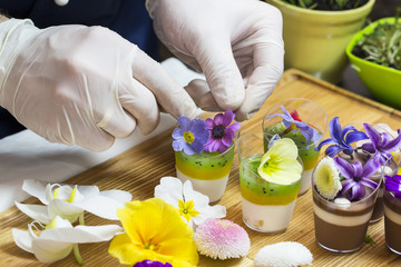 Obraz na płótnie Canvas cook prepares canapes dessert edible flowers and buds