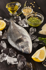 Fresh dorado fish on ice with pesto