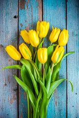bouquet of yellow tulips on a blue rustic background